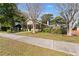 Tan house with green door and sidewalk, surrounded by trees at 931 And 925 Florida Ave, Palm Harbor, FL 34683