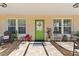 Covered porch with green door and patio furniture at 931 And 925 Florida Ave, Palm Harbor, FL 34683