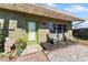 Small front porch with two chairs and a green front door at 931 And 925 Florida Ave, Palm Harbor, FL 34683