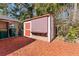 Outdoor storage shed with red door and wood siding at 931 And 925 Florida Ave, Palm Harbor, FL 34683
