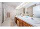 Bright bathroom with double sinks, a large mirror, and a walk-in shower at 113 Lindsay Ln # 23, Oldsmar, FL 34677