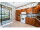 Traditional kitchen featuring wood cabinetry, tile flooring, and access to an outdoor patio at 113 Lindsay Ln # 23, Oldsmar, FL 34677
