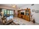 Comfortable living room with travertine floors, entertainment center and access to the sun room at 113 Lindsay Ln # 23, Oldsmar, FL 34677