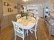 A charming dining area features a white table set for four, seamlessly connecting to a well-equipped kitchen at 117 S Saint Thomas Cir, Apollo Beach, FL 33572