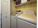 Functional laundry room with modern washer and dryer appliances, shelves, and plenty of storage at 117 S Saint Thomas Cir, Apollo Beach, FL 33572