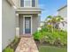 Front entryway with navy blue door and brick walkway at 11868 Little River Way, Parrish, FL 34219