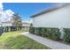 Well-maintained backyard with green grass, hedges, and a stone walkway leading to the side of the house at 12099 Gavin Ln, Odessa, FL 33556