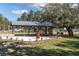Outdoor amenity space with seating, a grill, a stone wall, and lush landscaping at 12099 Gavin Ln, Odessa, FL 33556