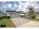 Home exterior with a two-car garage, paved driveway, manicured lawn, and well-kept hedges at 12099 Gavin Ln, Odessa, FL 33556