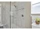 Glass enclosed shower featuring a neutral tile, plus a showerhead and shelving at 12099 Gavin Ln, Odessa, FL 33556