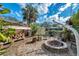 Landscaped backyard with fire pit, seating, wood storage and mature trees, perfect for outdoor entertaining at 1276 Bermuda St, Clearwater, FL 33755