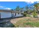 Exterior view of home's backyard with fence, grass, and building, ready for your landscaping ideas at 1276 Bermuda St, Clearwater, FL 33755