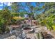 Spacious backyard featuring a fire pit, seating, mature trees, and a partially shaded lawn area at 1276 Bermuda St, Clearwater, FL 33755