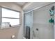 Close-up of shower with glass doors, tiled walls, and convenient storage caddy for toiletries at 1276 Bermuda St, Clearwater, FL 33755