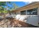 Exterior side view of home with white privacy fence and partially shaded yard with sidewalk at 1276 Bermuda St, Clearwater, FL 33755