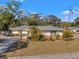 Charming single-story home with well-kept lawn, lush landscaping, a welcoming entrance, and a long paved driveway at 1276 Bermuda St, Clearwater, FL 33755