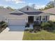 Tan one-story house with a two-car garage and landscaped yard at 13355 Waterleaf Garden Cir, Riverview, FL 33579