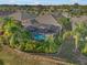 Aerial view of a home with a private screened pool, surrounded by lush tropical landscaping at 1607 Emerald Dunes Dr, Sun City Center, FL 33573