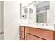 Bright bathroom vanity with wood cabinets, white countertop and a glimpse of a shower in the background at 16216 Rambling Vine W Dr, Tampa, FL 33624