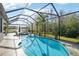 A screened pool with a hot tub overlooking a pond at 18863 Roseate Dr, Lutz, FL 33558
