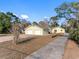 Exterior view of a yellow house with a double garage and long driveway at 2050 Glenridge Dr, Spring Hill, FL 34609