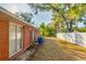 Backyard view showing the brick exterior with a sliding glass door and trash bins at 206 N Highland Ave, Clearwater, FL 33755