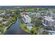 Aerial shot highlights the white, mid-rise condo overlooking a lake and lush grounds at 220 Belleview Blvd # 108, Belleair, FL 33756
