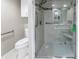 Accessible bathroom featuring tiled shower with glass doors, shower seat, and grab bars for safety and convenience at 220 Belleview Blvd # 108, Belleair, FL 33756