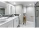 Modern bathroom with double sink, white cabinets, and glass door shower at 220 Belleview Blvd # 108, Belleair, FL 33756