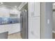 Bright white kitchen with modern stainless steel refrigerator and ample cabinet storage at 220 Belleview Blvd # 108, Belleair, FL 33756