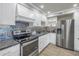 Well-lit kitchen with stainless steel appliances, dark countertops, and stylish backsplash at 220 Belleview Blvd # 108, Belleair, FL 33756