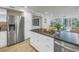 Bright kitchen island with dark granite countertops and stainless steel refrigerator in an open floor plan at 220 Belleview Blvd # 108, Belleair, FL 33756
