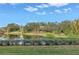 Lake with manicured shrubbery and grassy lawns with shade trees at 220 Belleview Blvd # 108, Belleair, FL 33756