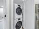 Efficient laundry area featuring a stacked washer and dryer unit, maximizing space and convenience at 220 Belleview Blvd # 108, Belleair, FL 33756