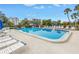 Community pool with lounge chairs and tropical landscaping is perfect for relaxation at 220 Belleview Blvd # 108, Belleair, FL 33756