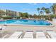 Beautiful swimming pool with lounge chairs, palm trees, and clear blue water, perfect for relaxation and recreation at 220 Belleview Blvd # 108, Belleair, FL 33756