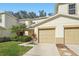 Attractive townhouse featuring a two-car garage, healthy green lawn, and freshly trimmed shrubs at 2938 Royal Tuscan Ln, Valrico, FL 33594