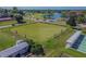 Aerial view showcasing the lawn bowling field alongside the road and pond at 301 Andover S Pl # 185, Sun City Center, FL 33573