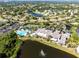 Aerial view of homes in a landscaped community with a pool and tennis courts at 301 Andover S Pl # 185, Sun City Center, FL 33573