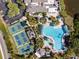Aerial view of a community pool, landscaping, and tennis courts at 301 Andover S Pl # 185, Sun City Center, FL 33573