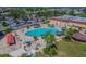 Aerial view of the community pool and lots of people relaxing on lounge chairs and swimming at 301 Andover S Pl # 185, Sun City Center, FL 33573