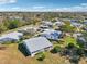 Aerial view of a property featuring a light grey roof, landscaping, and cozy curb appeal with bicycle and shrubbery at 301 Andover S Pl # 185, Sun City Center, FL 33573