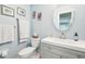 Bright bathroom features a vanity, toilet and a round mirror at 301 Andover S Pl # 185, Sun City Center, FL 33573