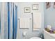 Cozy bathroom with blue walls, framed artwork, and coordinating striped shower curtain at 301 Andover S Pl # 185, Sun City Center, FL 33573