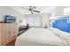Bright bedroom with a white bedspread, ceiling fan and dresser at 301 Andover S Pl # 185, Sun City Center, FL 33573