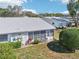 Home exterior showcasing the screened-in porch, neatly maintained yard, and cozy curb appeal with bicycle and shrubbery at 301 Andover S Pl # 185, Sun City Center, FL 33573