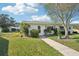 Inviting front yard featuring lush landscaping and a charming walkway leading to the front door at 301 Andover S Pl # 185, Sun City Center, FL 33573