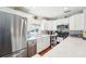 Modern kitchen with stainless steel refrigerator, white cabinets, and a blue tiled backsplash at 301 Andover S Pl # 185, Sun City Center, FL 33573