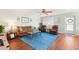 Cozy living room featuring a comfortable seating arrangement with a vibrant blue rug and stylish decor, illuminated by natural light at 301 Andover S Pl # 185, Sun City Center, FL 33573