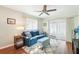 Comfortable living room with a blue sofa, patterned ottoman, and sliding glass door to the lanai at 301 Andover S Pl # 185, Sun City Center, FL 33573